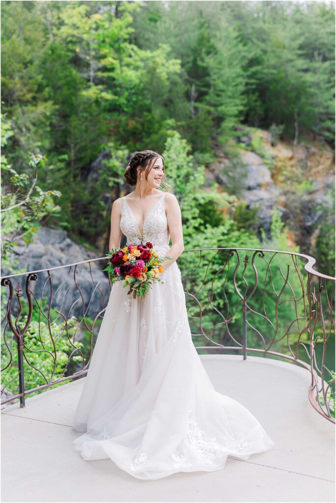 Bride with flower bouquet smiles into distance at waterstone wedding johnson city