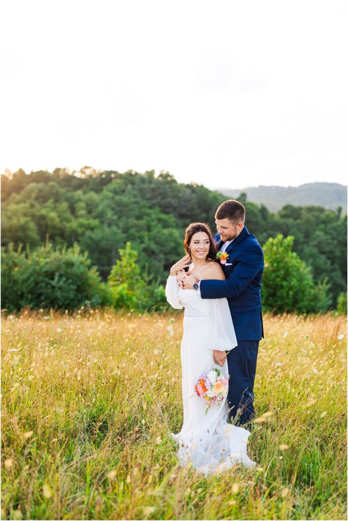 Bride and Groom in Glade Creek Farm field with mountains in background