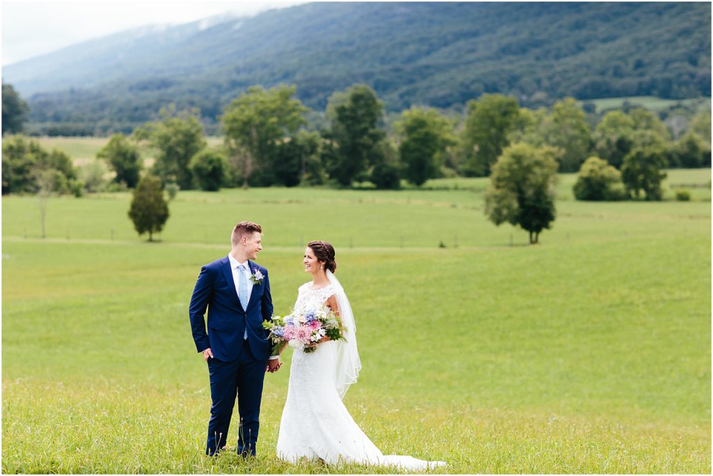 Bride and groom holding hands in field at Crooked RIver Farm Hiltons, VA