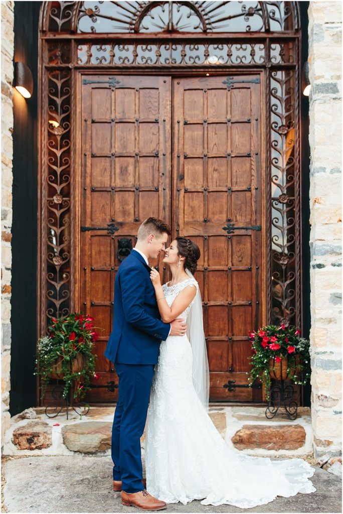 Crooked River Farm Wedding venue photographer from Bristol VA posing in front of wooden accent door with Bristol va wedding photographer