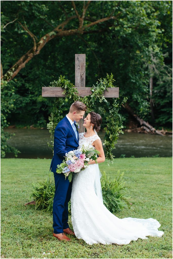 HIltons VA wedding venue bride and groom smiling with wooden cross in background  pictures with Bristol VA wedding photographer Crooked River Farm Wedding Venue