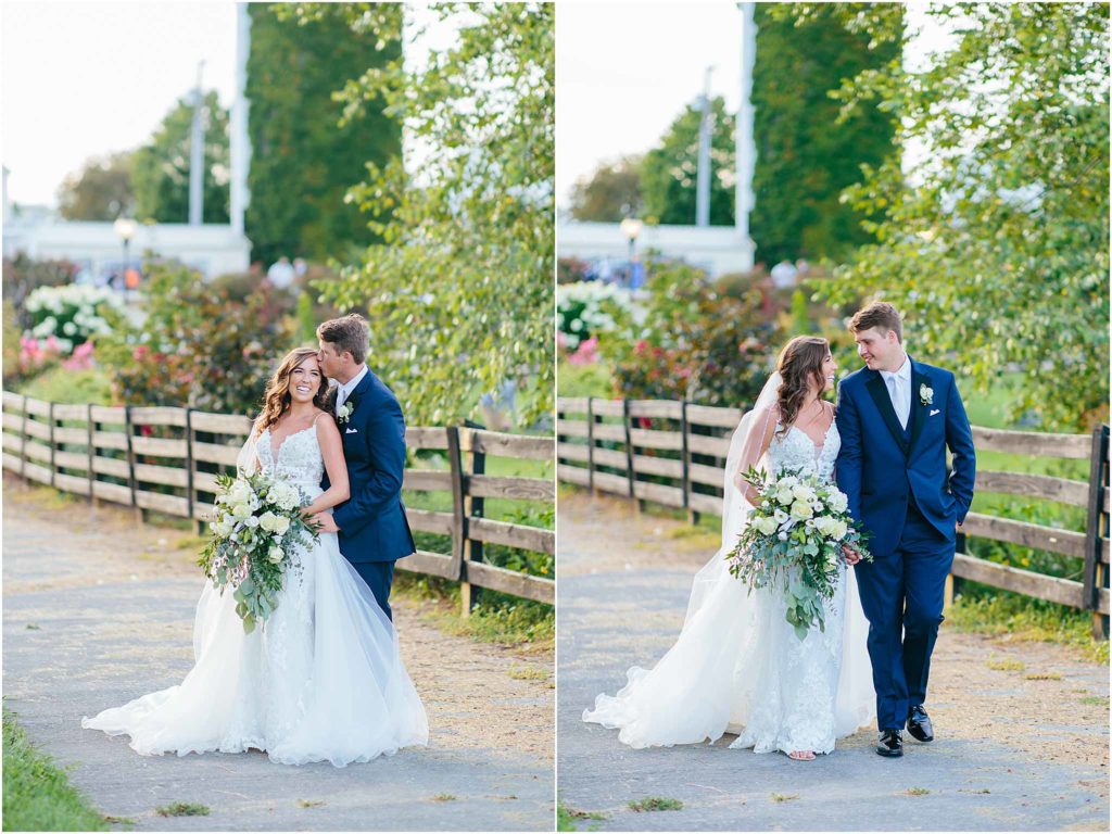 Bride and groom on driveway with sinkland farms wedding silo behind fence 