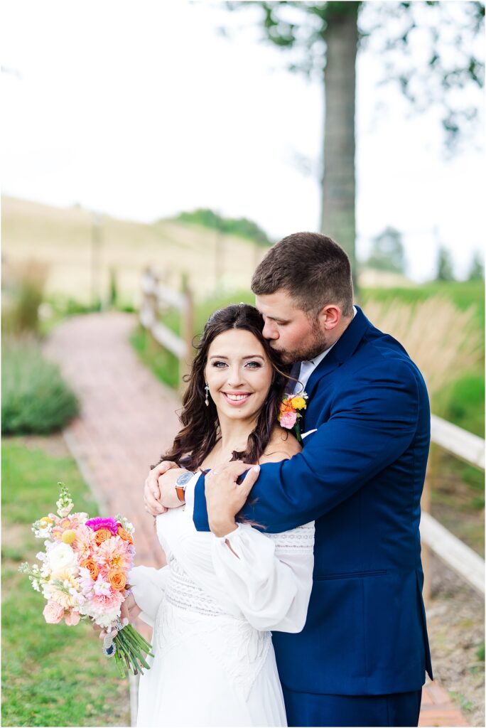 Husband kisses wife on temple at west virginia wedding venue glade creek farm