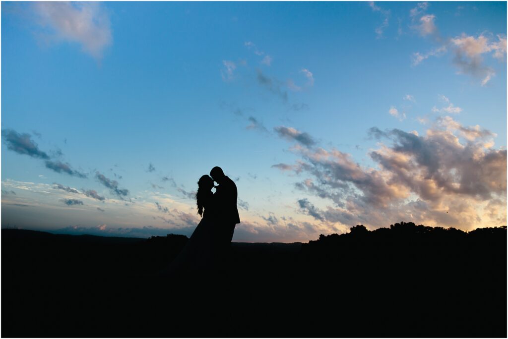 Couple kiss at sunset with glade creek farm in distance