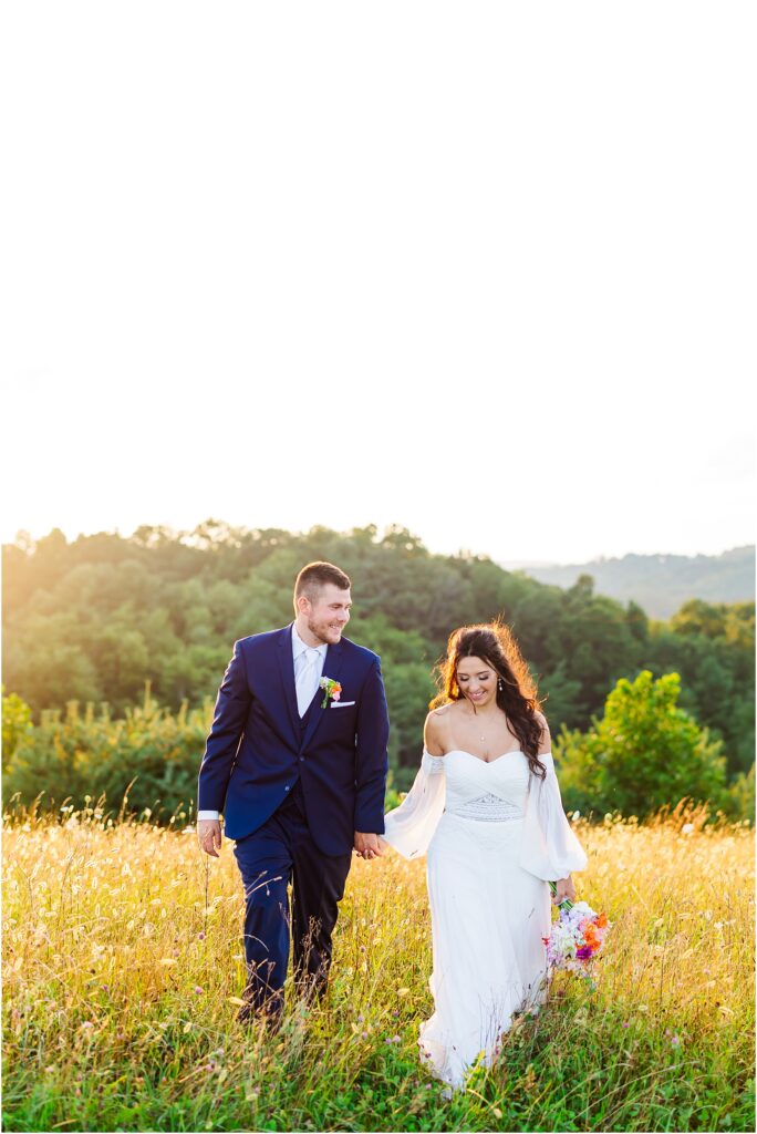 Golden Hour walking bride and groom in field of Glade Creek Farm